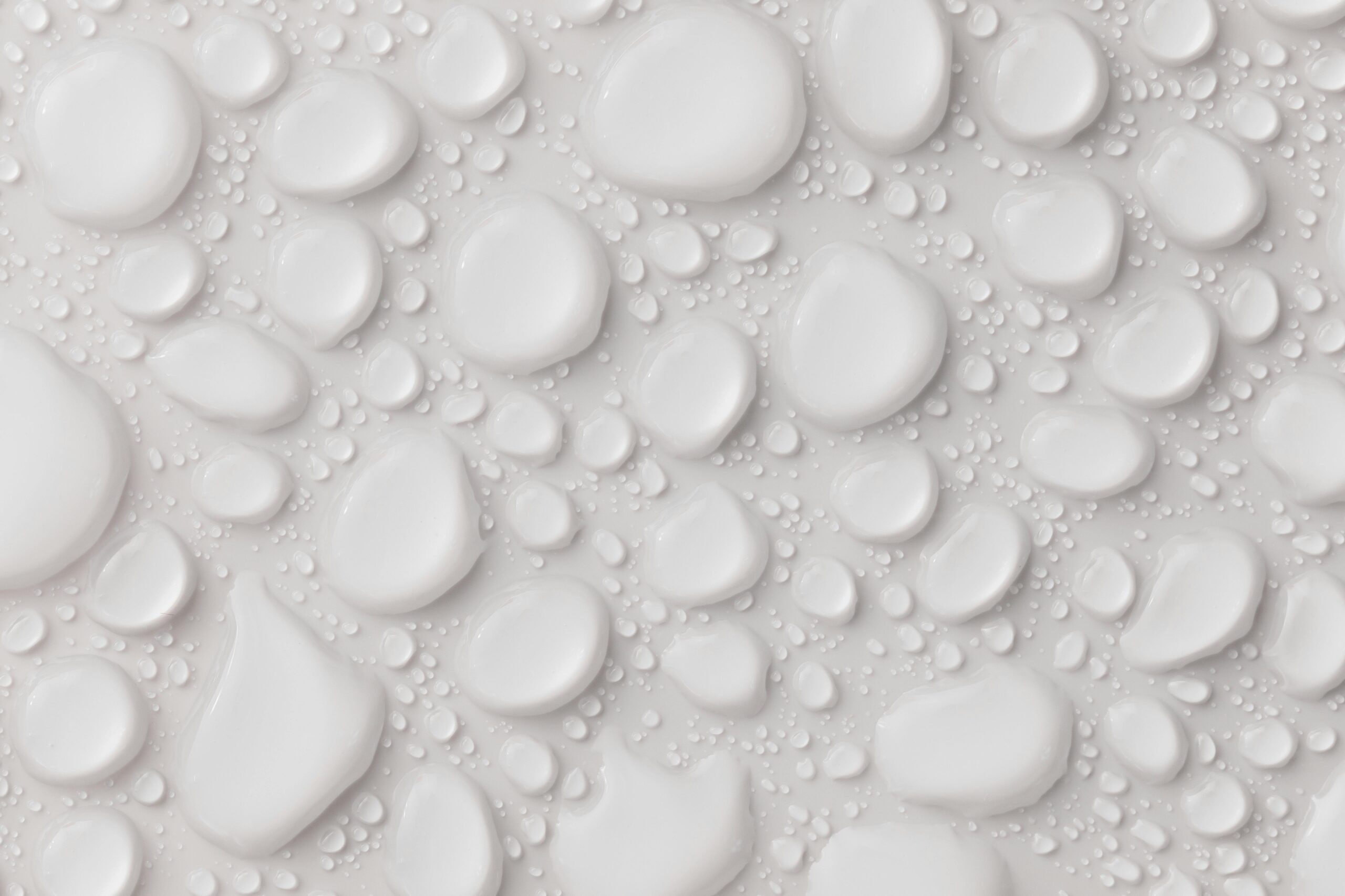 Close-up of abstract white water droplets on a smooth surface, ideal for background or texture.